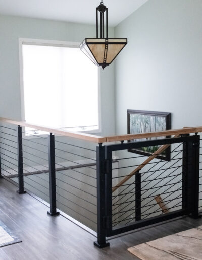 Newly remodeled staircase featuring an iron and cable design